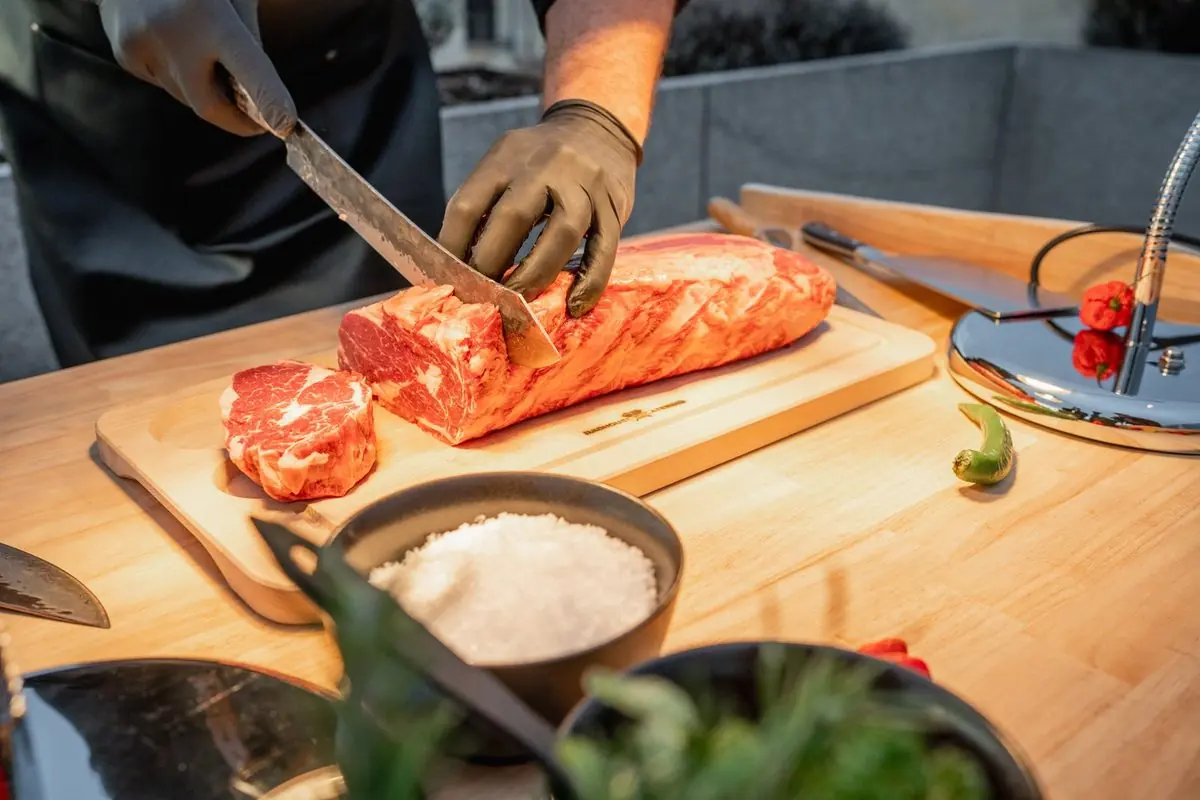 Catering na vánoční večírek — krájení uzeného masa před hosty